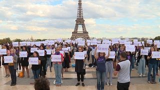 People write the names of women killed during a rally in Paris