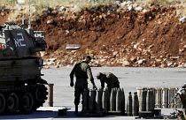 جنود إسرائيليون يقفون بجانب القذائف ووحدة مدفعية متحركة بالقرب من الجانب الإسرائيلي من الحدود مع سوريا- أرشيف رويترز