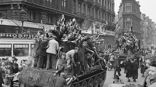 Belgian civilians cheer British troops in Brussels on September 4, 1944. 