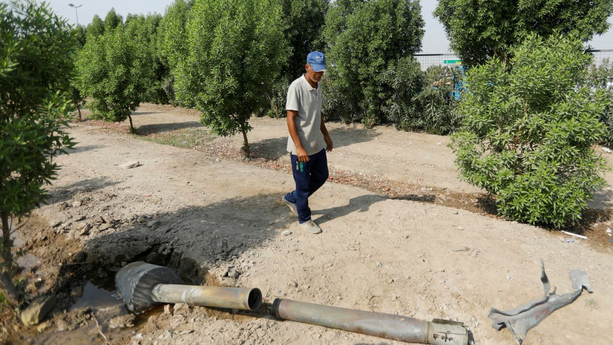 رجل ينظر إلى قذيفة في حديقته قرب بغداد- أرشيف رويترز