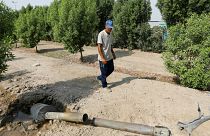 رجل ينظر إلى قذيفة في حديقته قرب بغداد- أرشيف رويترز