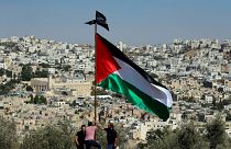 متظاهرون يرفعون العلم الفلسطيني خلال احتجاج على الزيارة المزمعة لرئيس الوزراء الإسرائيلي نتنياهو إلى مدينة الخليل في الضفة الغربية