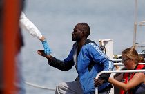 İtalya'da kurtarma gemisinden çıkartılan bir göçmen