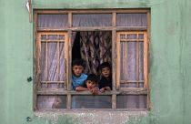 Afghan children look out from a broken window at the site of a blast in Kabul