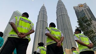 حراس أمن خارج أبراج بتروناس في كوالا لامبور-ماليزيا