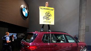 نشاطة "السلام الأخضر" تعتلي سيارة بي إم دبليو رباعية الدفع احتجاجا على تأثيرها السلبي على المناخ