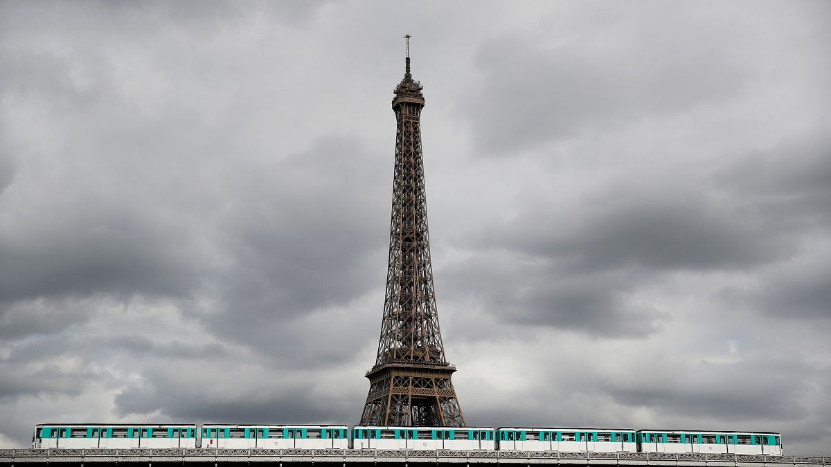 An elevated Metro passes over a bridge next to the Eiffel Tower in Paris on the eve of a strike by all unions of the Paris transport network (RATP) against pension reform.