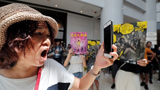 A woman reacts near anti-government supporters at Olympian City 2 shopping mall in Hong Kong, China, September 13, 2019.