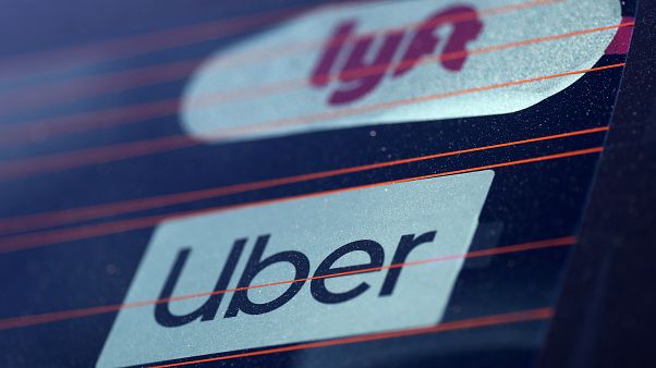 Uber and Lyft signs are seen on a car in Redondo Beach Uber and Lyft signs are seen on a car in Redondo Beach