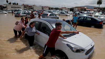 أناس يدفعون سيارة داخل مرآب غمرته مياه الفيضان في أوريولا الإسبانية. 2019/09/13. جون نازا - رويترز