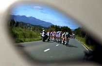 A Vuelta spanyol körverseny mezőnye egy autó visszapillantó tükrében