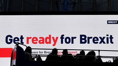 A bus passes an electronic billboard displaying a British government Brexit information awareness campaign advertisement in London, Britain