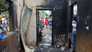 A man looks into a burned building after a fire swept through a school killing children in Monrovia