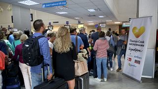 People line up in front of a counter of Thomas Cook at the Heraklion airport on the island of Crete, Greece September 23, 2019