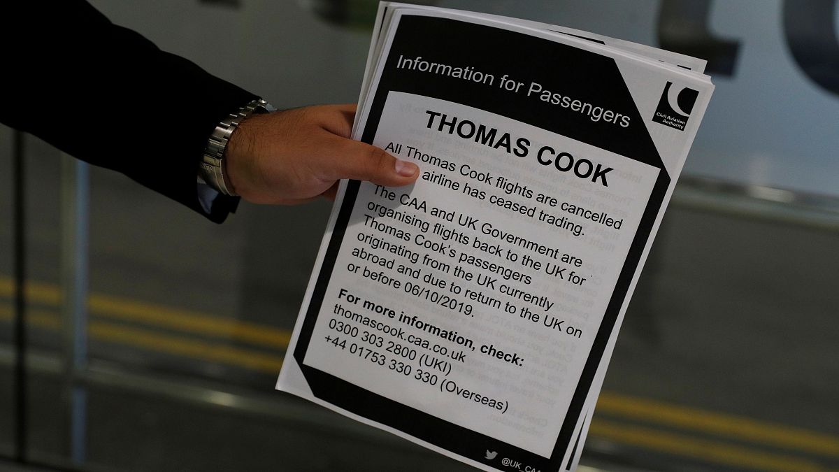A man holds information on Thomas Cook flights at Manchester Airport, Manchester, Britain September 23, 2019.