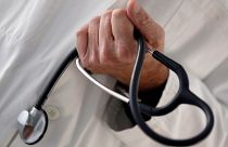 FILE PHOTO: A photo illustration shows a French general practitioner holding a stethoscope in a doctor's office in Bordeaux