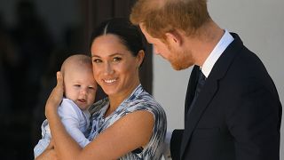 Britain's Prince Harry and his wife Meghan, Duchess of Sussex, holding their son Archie, meet Archbishop Desmond Tutu (not pictured)