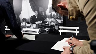 A man signs the book of condolences in front of Paris city hall to pay tribute to late former French President Jacques Chirac in Paris, France, September 26, 2019.