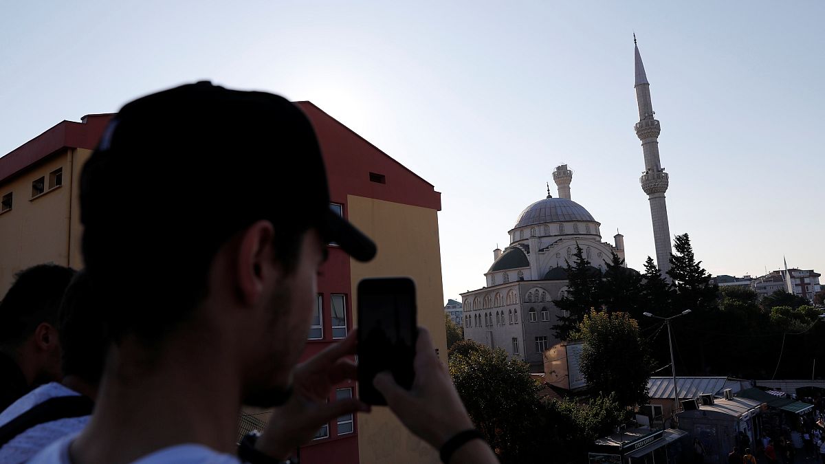 A man takes a picture of a damaged mosque in Istanbul following the earthquake