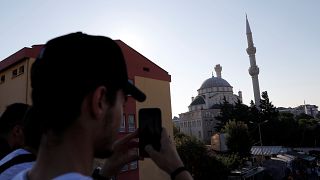 A man takes a picture of a damaged mosque in Istanbul following the earthquake