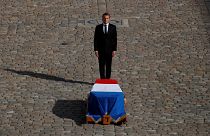 French President Emmanuel Macron stands in front of the flag-draped coffin of late French President Jacques Chirac during a military funeral honors ceremony