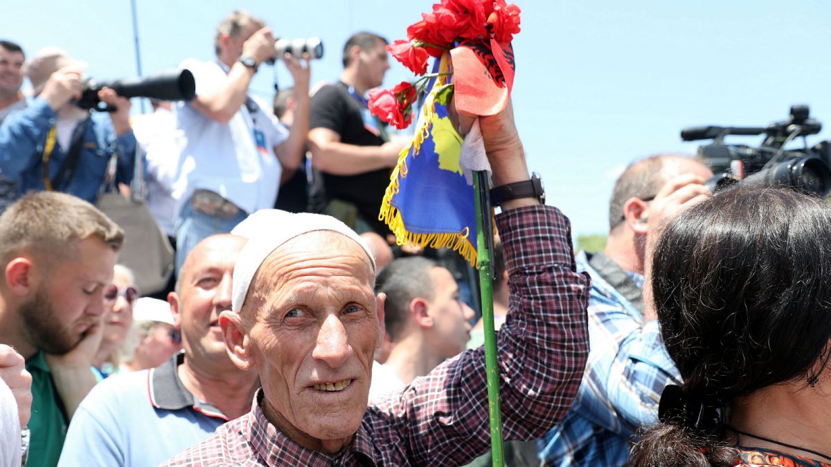 A man holding flags of Albania and Kosovo attends the 20th anniversary of the deployment of NATO Troops in Kosovo in Pristina, Kosovo June 12, 2019.