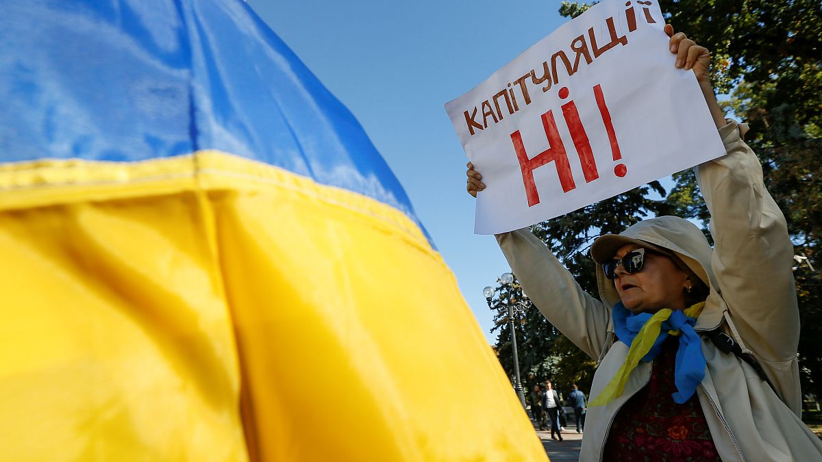 A woman attends a rally against approval of so-called Steinmeier Formula, in Kiev, Ukraine October 2, 2019. A sign on a poster reads: "No surrender!"