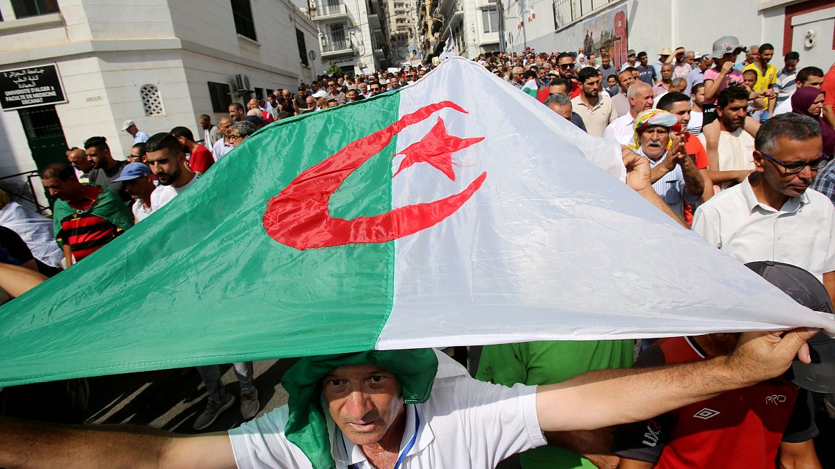المتظاهرون يحملون العلم الوطني خلال احتجاج في الجزائر 1 أكتوبر/ تشرين الأول