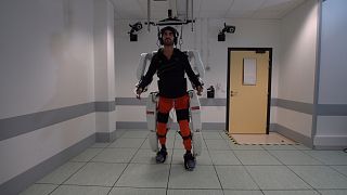 A patient with tetraplegia walks using an exoskeleton in Grenoble, France, in February 2019, in this still image taken from a video handout.