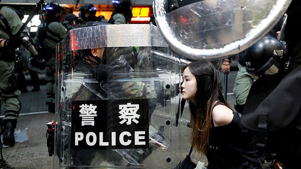 Uma manifestante é detida pela polícia antimotim em Hong Kong Uma manifestante é detida pela polícia antimotim em Hong Kong