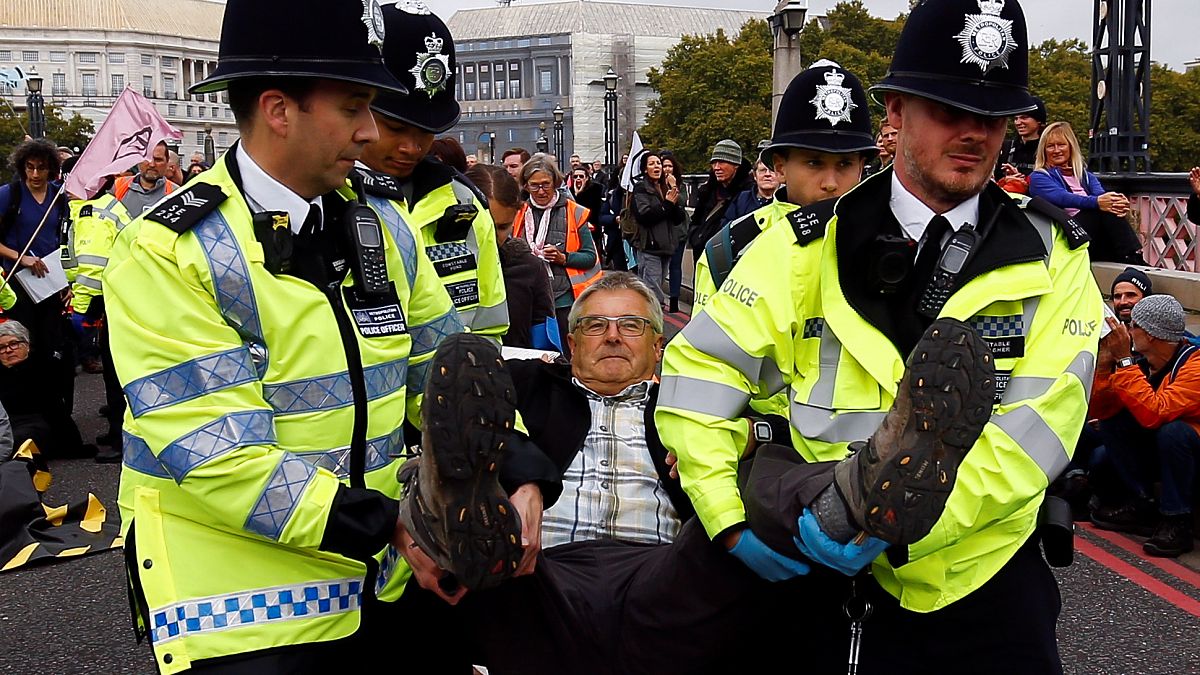 Police officers detain an activist at Lambeth Bridge during the Extinction Rebellion protest in London, Britain October 7, 2019.