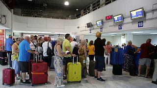 مسافرون يصطفّون في طابور أمام مكاتب "توماس كوك" في مطار هيراكليون باليونان