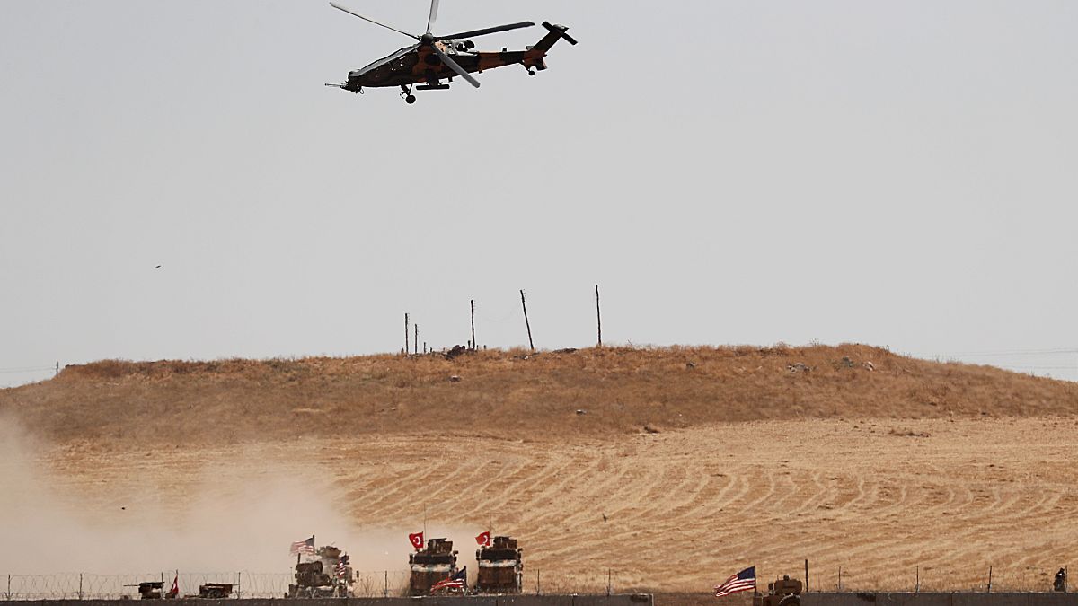 طائرة هليكوبتر عسكرية تركية مع القوات التركية والأميركية على الأرض خلال دورية مشتركة بين الولايات المتحدة وتركيا في شمال سوريا