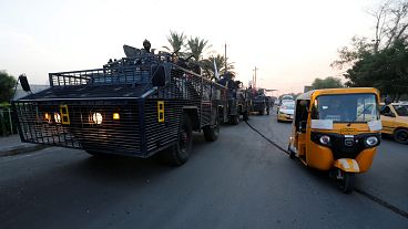 توك توك بجانب مدرعة في أحد شوارع بغداد، العراق ، 7 تشرين الأول (أكتوبر) 2019.