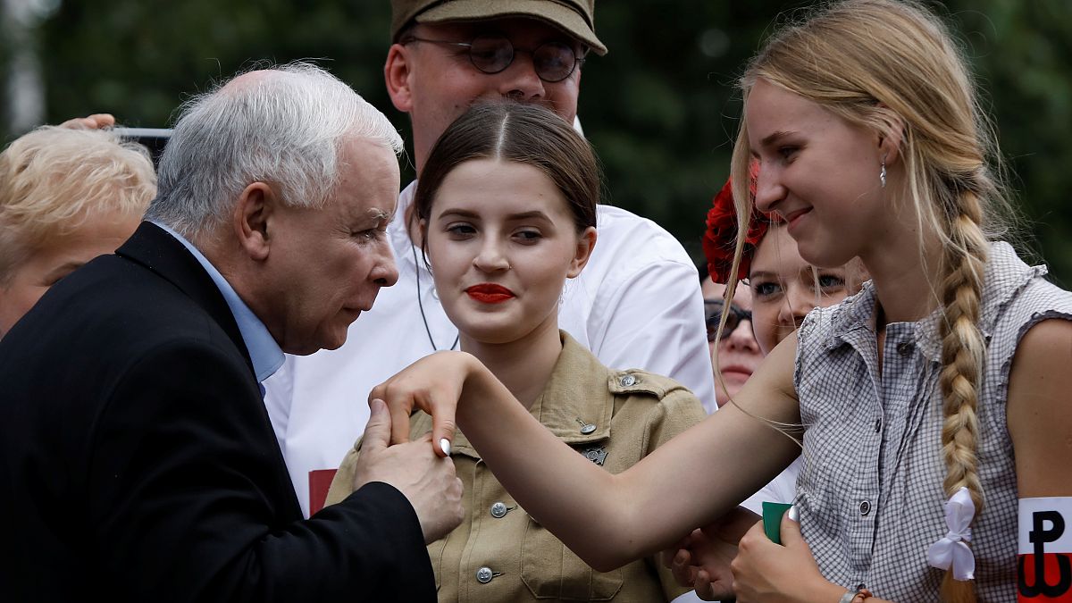 رئيس الحزب الحاكم ياروسلاف كاتشنسكي يقبل يد شابة من مؤيدات حزب القانون والعدالة