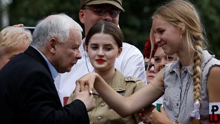 رئيس الحزب الحاكم ياروسلاف كاتشنسكي يقبل يد شابة من مؤيدات حزب القانون والعدالة