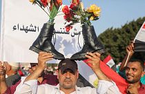 أحد أنصار الرئيس المصري عبد الفتاح السيسي يحمل أحذية عسكرية فوق رأسه وهو يهتف بالشعارات في القاهرة