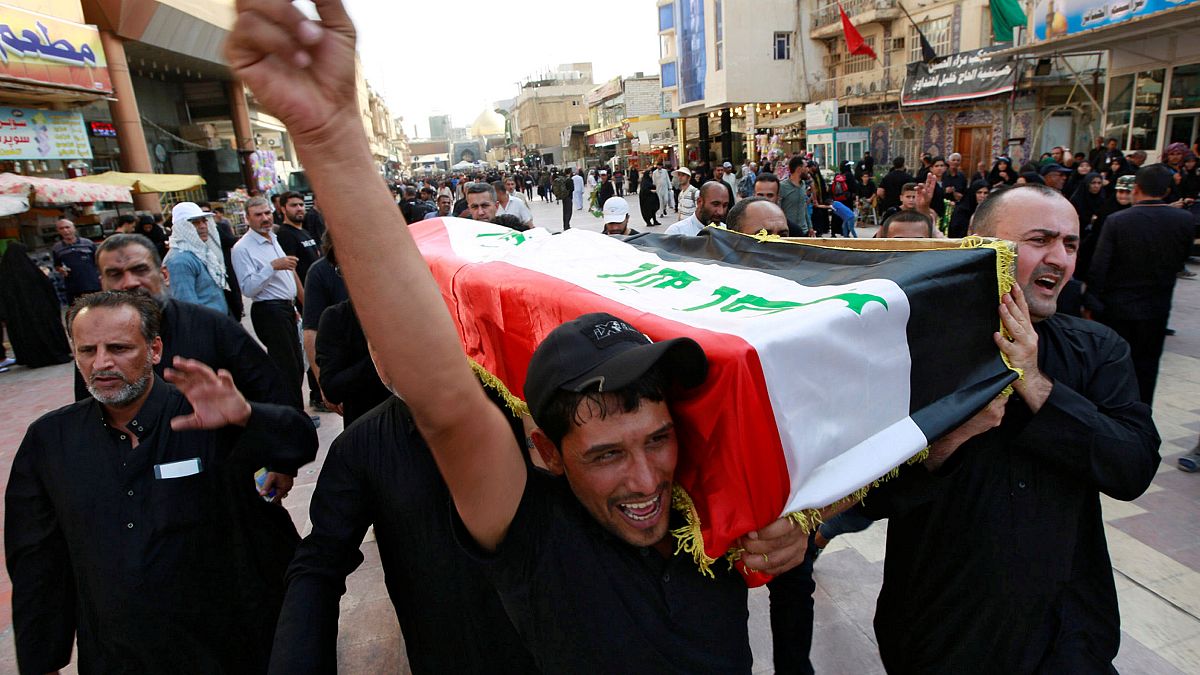 رجال عراقيون يحملون نعش أحد المتظاهرين قُتل أثناء الاحتجاجات المناهضة للحكومة، في جنازة في النجف، العراق، 7 أكتوبر / تشرين الأول 2019