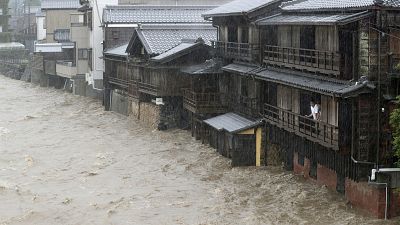 مواطن ينظر من نافذة بيته إلى الفيضانات في "آيس" وسط اليابان بعد ان فاضت مياه نهر إزيوزو بسبب الأمطار الغزيرة. 12 أكتوبر 2019