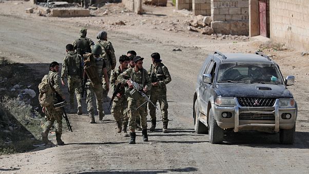Turkey-backed Syrian rebel fighters walk together near the border town of Tel Abyad, Syria, October 12, 2019. Turkey-backed Syrian rebel fighters walk together near the border town of Tel Abyad, Syria, October 12, 2019.