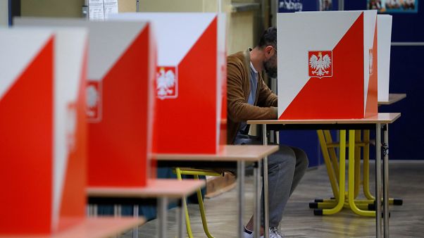A man attends a voting during parliamentary election at a polling station in Warsaw, Poland, October 13, 2019. A man attends a voting during parliamentary election at a polling station in Warsaw, Poland, October 13, 2019.