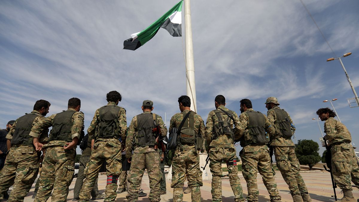 Milícias sírias apoiadas pela Turquia içam bandeira na sidade de Tel Abyad