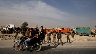 People ride on a motorbike in the city of Manbij, Syria October 15, 2019. 