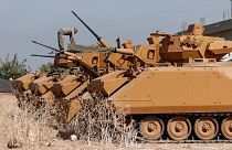 A Turkish soldier stands on top of an armoured personnel carrier near the Turkish-Syrian border in Sanliurfa province