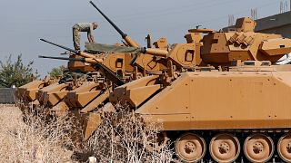 A Turkish soldier stands on top of an armoured personnel carrier near the Turkish-Syrian border in Sanliurfa province
