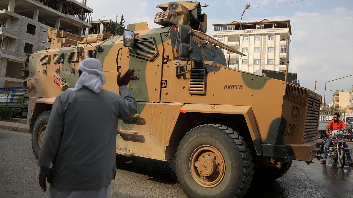 رجل يلوح لمدرعة تابعة للجيش التركي في أقجة قلعة