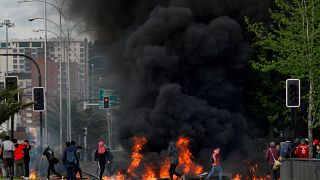 Demonstrators stand next to a burning barricade in Concepcion, Chile October 20, 2019