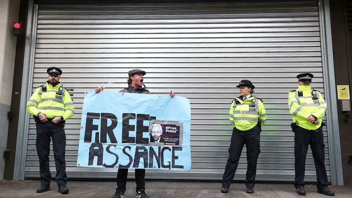 A demonstrator holds a banner during a protest outside a London court, Britain, October 21, 2019. 