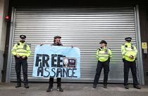 A demonstrator holds a banner during a protest outside a London court, Britain, October 21, 2019.