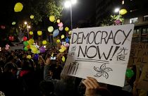 A person holds a placard as pro-independence activists throw balloons during a protest outside the Spanish government delegation offices in Barcelona, Spain October 21, 2019.